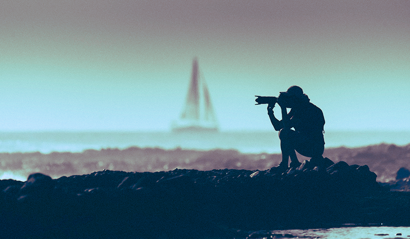 Journalist photographing a sailboat